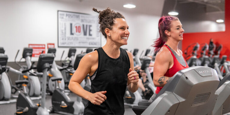 una mujer sonriente haciendo ejercicio en una cinta de correr en el centro de Cabot