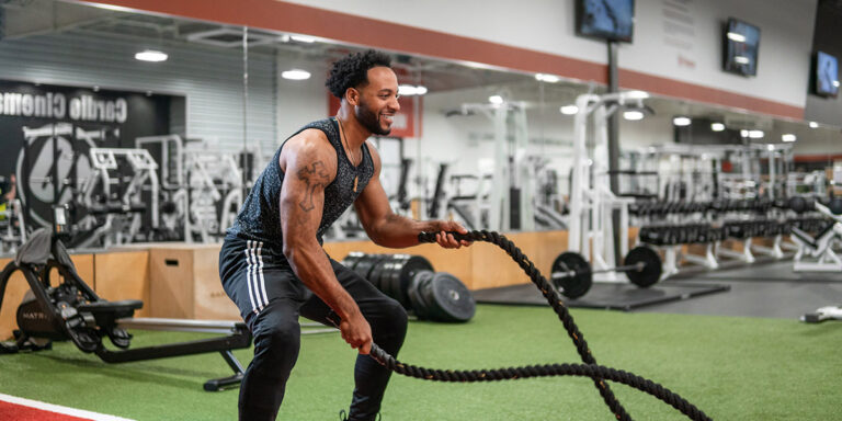 un hombre usando las cuerdas pesadas en el club Cabot