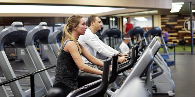 una mujer y un hombre utilizando el equipo de cardio en el club de Jonesboro