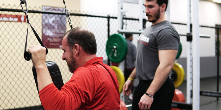 Un entrenador personal supervisa un entrenamiento en el club de Jonesboro