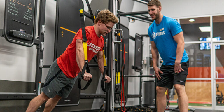 un entrenador personal supervisando un entrenamiento en el club de Paragould