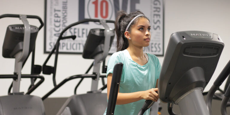 a woman using a cardio machine at the Searcy club