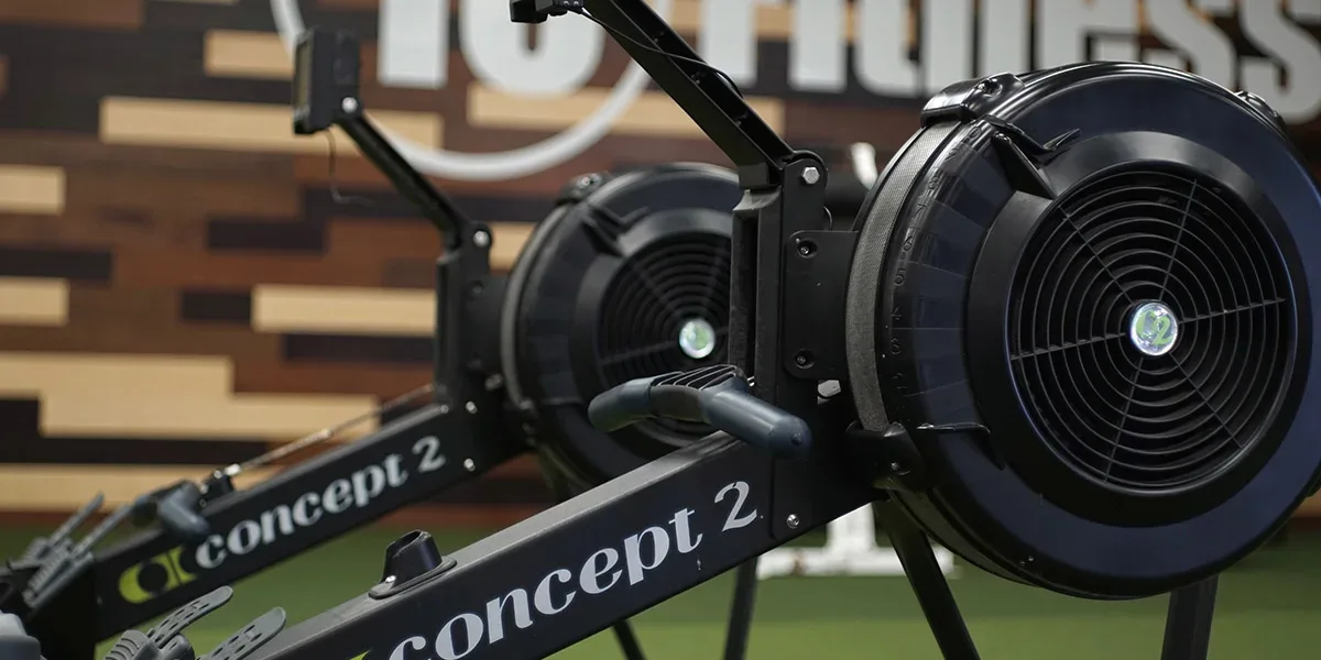 Person using rowing machine at 10 Fitness gym in Arkansas