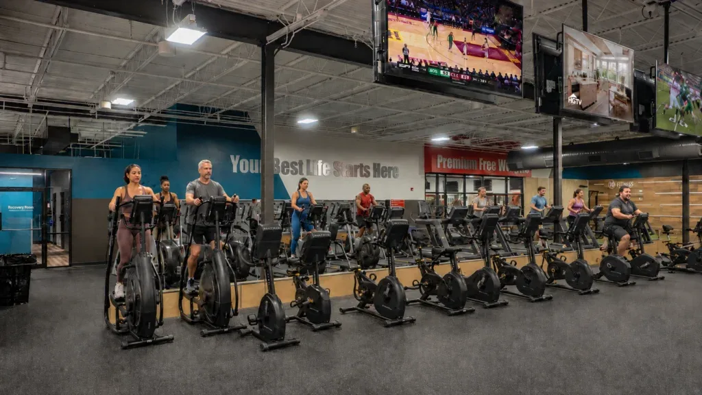 Busy gym floor with cardio machines including treadmills and ellipticals at 10 Fitness